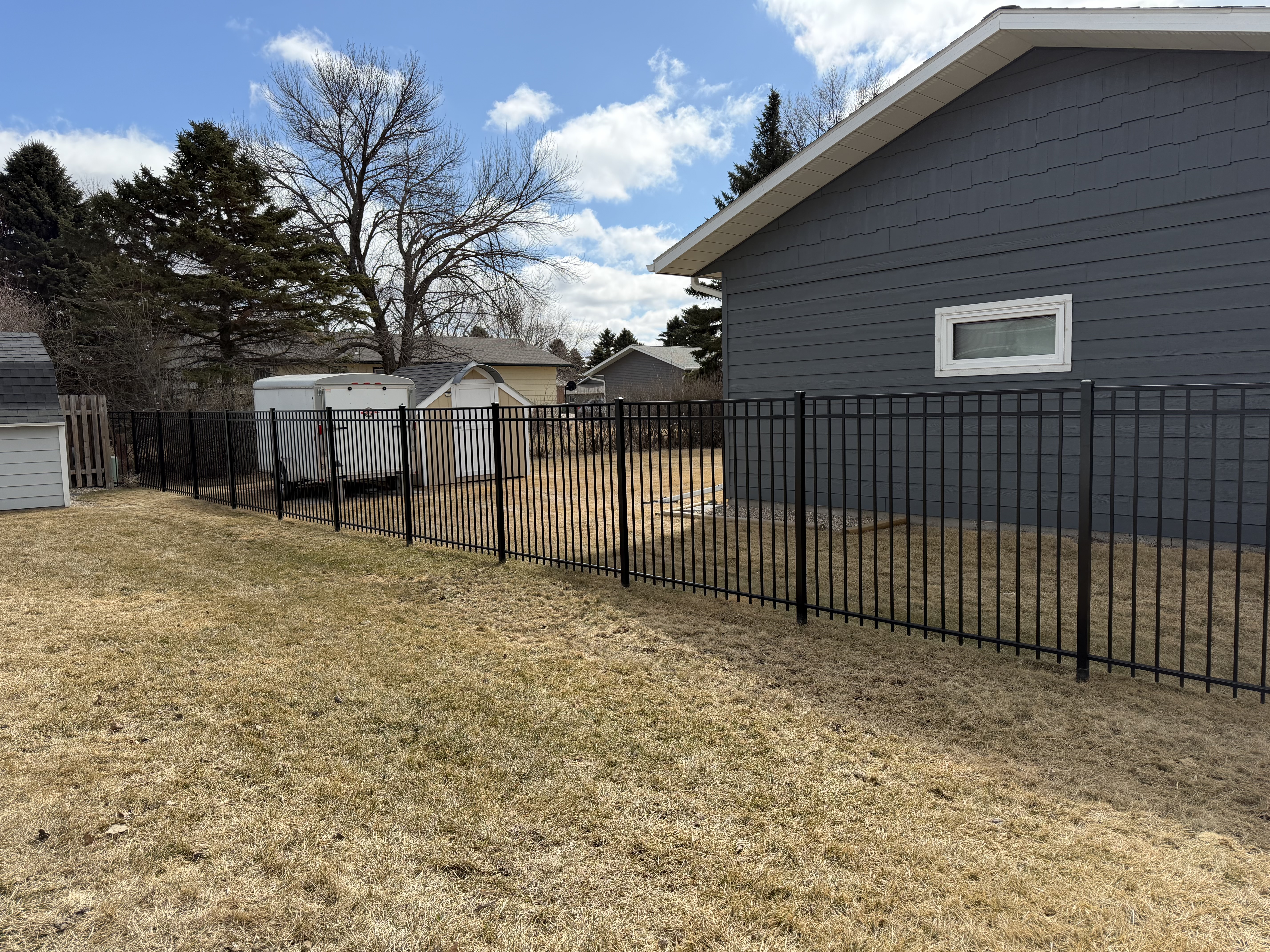Black ornamental metal residential fence installation
