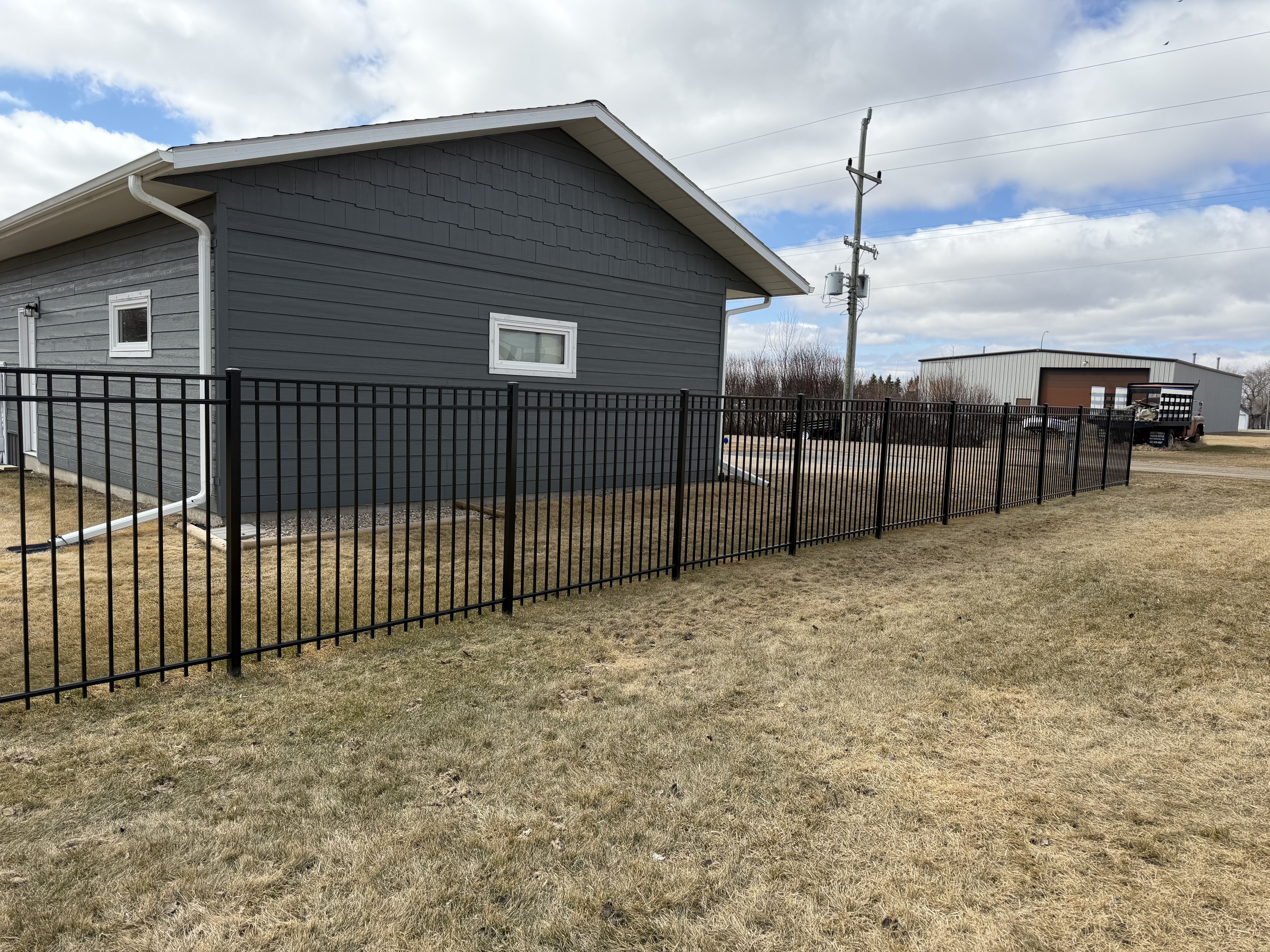Black ornamental side-yard fence installation