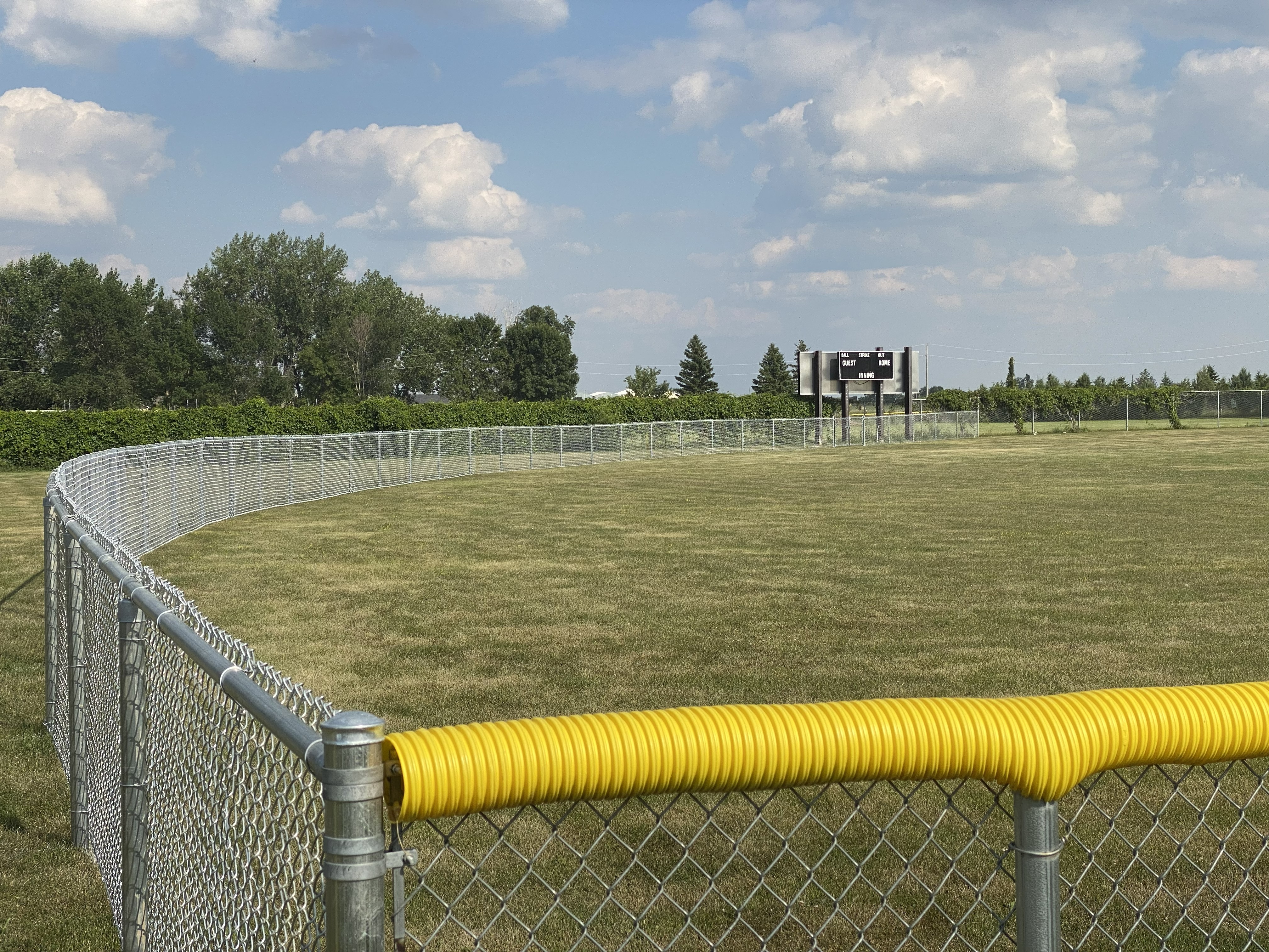 Outfield chain link fence along grass warning track