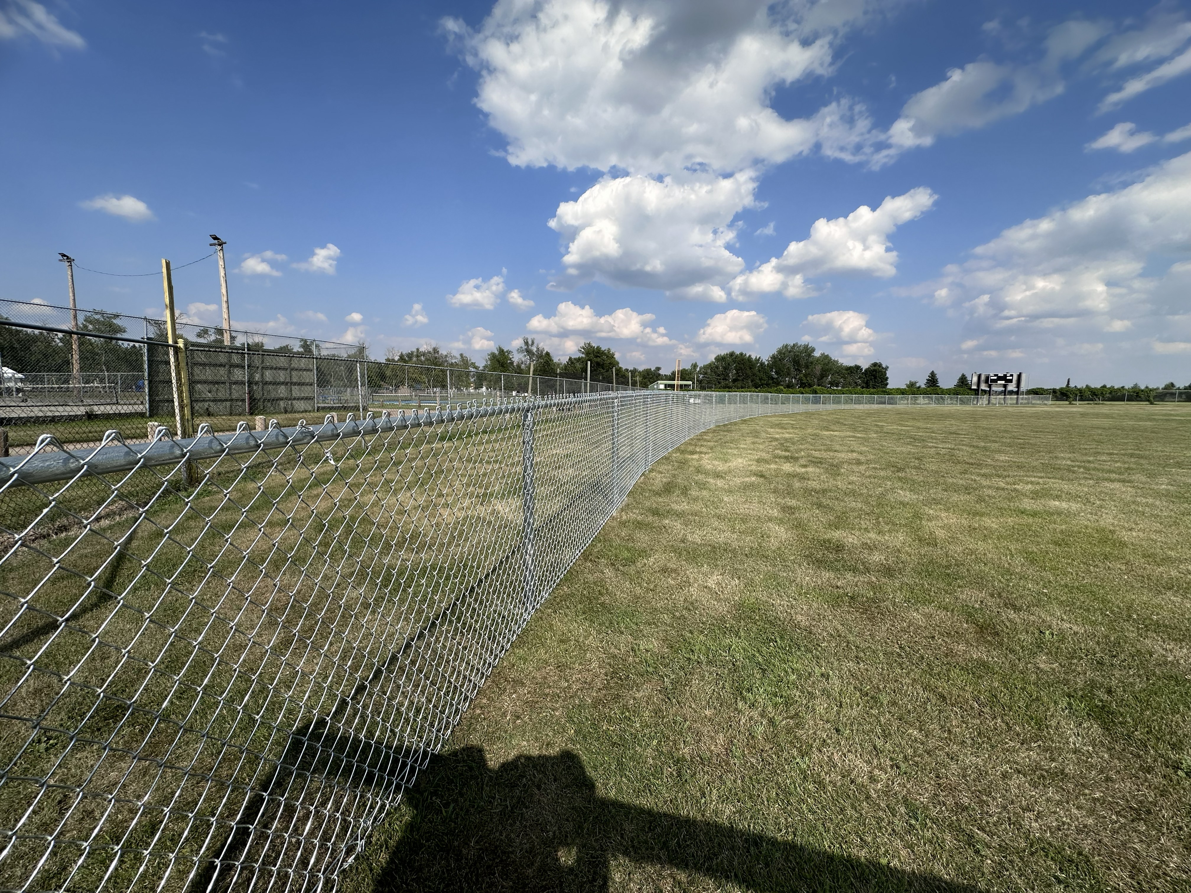 Curved chain link outfield fence installation
